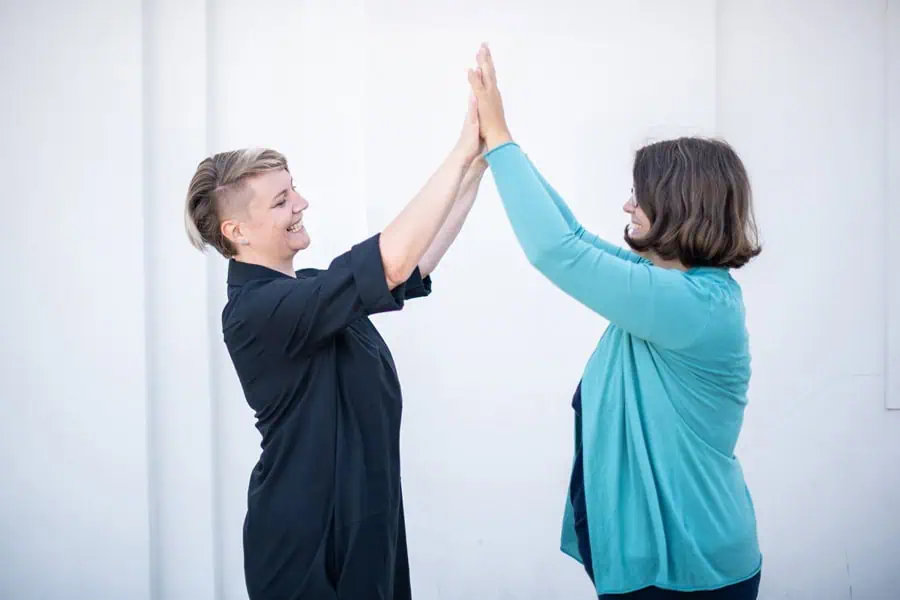 Marie Meyer Marktl schlägt mit einer Kundin die Hände zusammen.