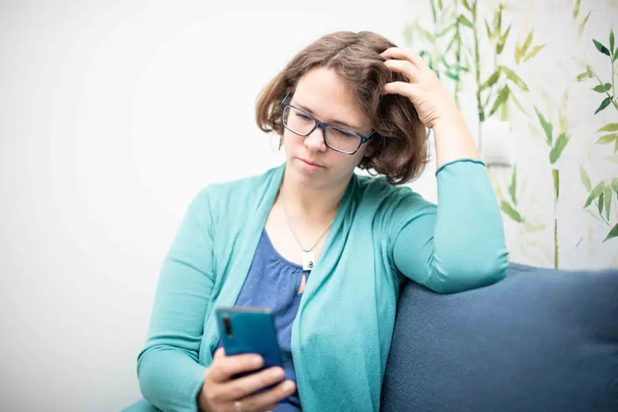 Zeitmanagement: Marie Meyer Marktl schaut müde auf ihr Handy.