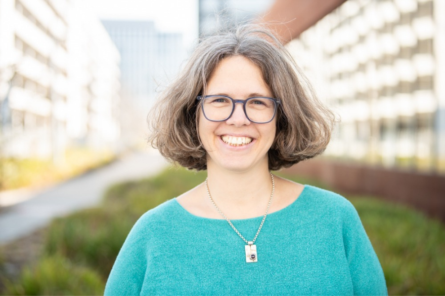 Life Coach Marie Meyer-Martkl steht im Sonnenlicht und lächelt in die Kamera. Sie trägt ein blaues Oberteil und strahlt Selbstbewusstsein aus, das sie gerne an dich weitergeben möchte. Das Bild wirkt sehr harmonisch, warm und motivierend.