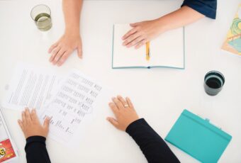 Hände auf dem Schreibtisch.