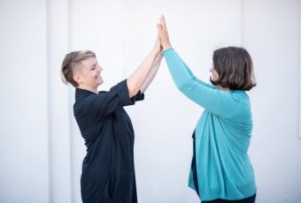 Marie Meyer Marktl schlägt mit einer Kundin die Hände zusammen.