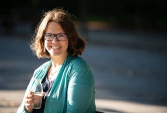 Marie Meyer Marktl sitzt auf einer Bank.